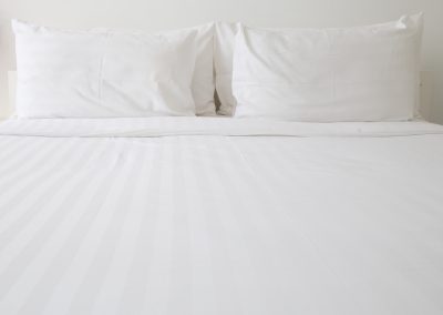 Tightly made bed after house cleaning service