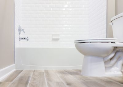 Sparkling clean white bathroom with wood floors after house cleaning service